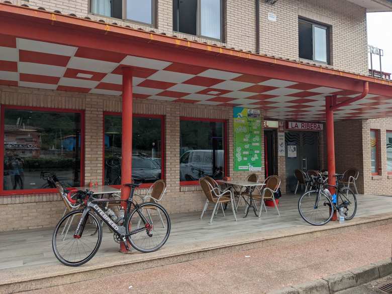 A black Litespeed Archon C2 and black Ghost carbon fiber bicycle outside Restaurante La Ribera/Hotel Aventura Rio Sella.