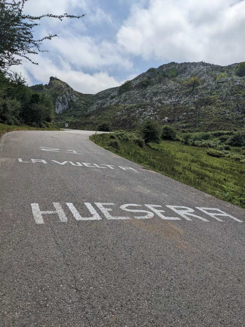 An uphill road marked with words "Huesera La Vuelta 21"