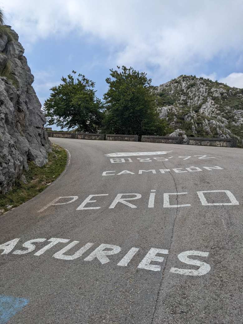 Uphill road marked in white words "Asturies Perico Campeón 8185'92"