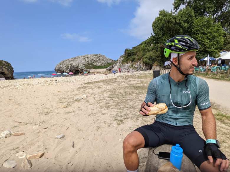 Marcos eating a bocata (small sandwich) on the Playa de Cuevas del Mar in Asturias.