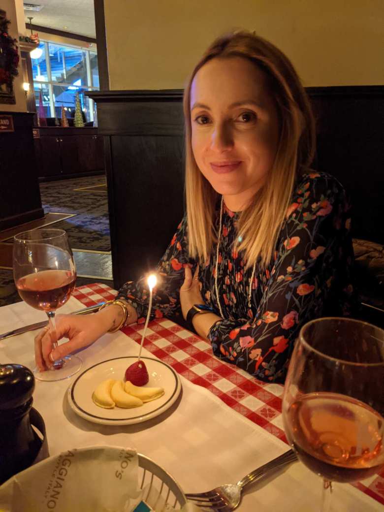 Andrea with a birthday candle coming out of a strawberry at Maggiano's.