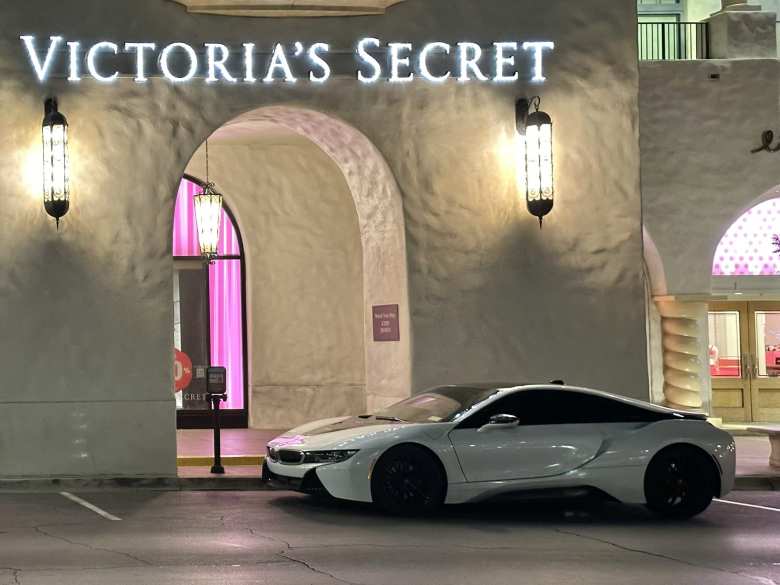 A white BMW i8 parked outside Victoria's Secret.