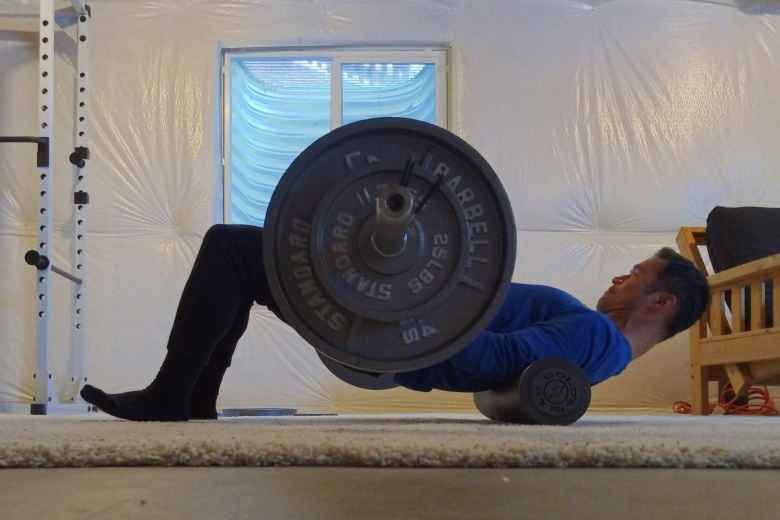 Doing hip thrusts in the basement on a foam roller.