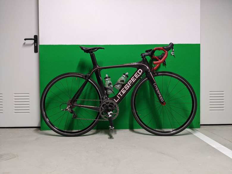 My black Litespeed Archon C2 against a green and white wall in our parking garage.