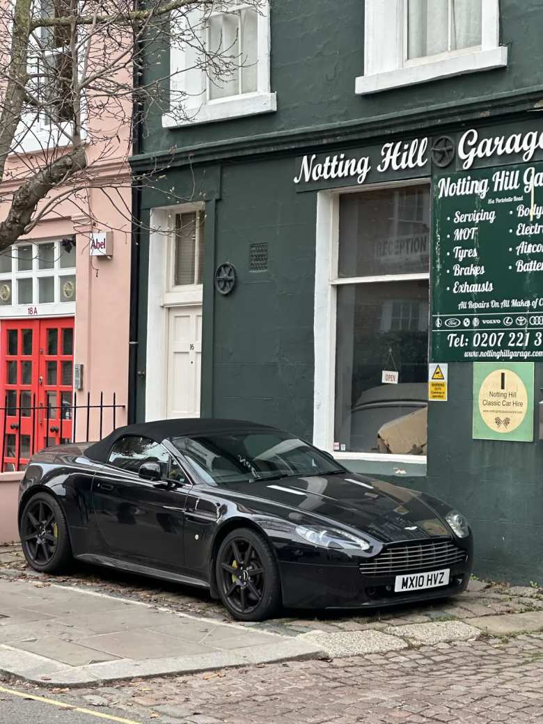 A black Aston Martin convertible at Notting Hill Garage.