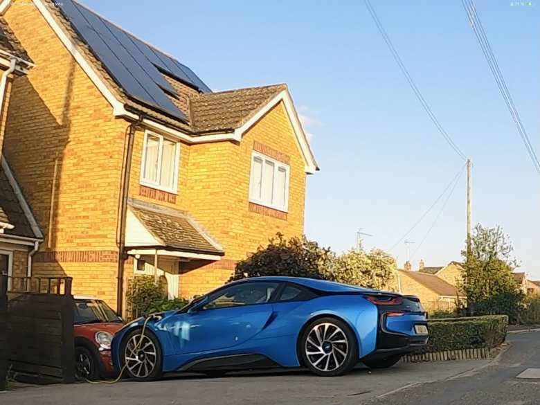 A blue BMW i8 being charged outside a home near Ramsey, UK. A blue BMW i8 being charged outside a home near Ramsey, UK.