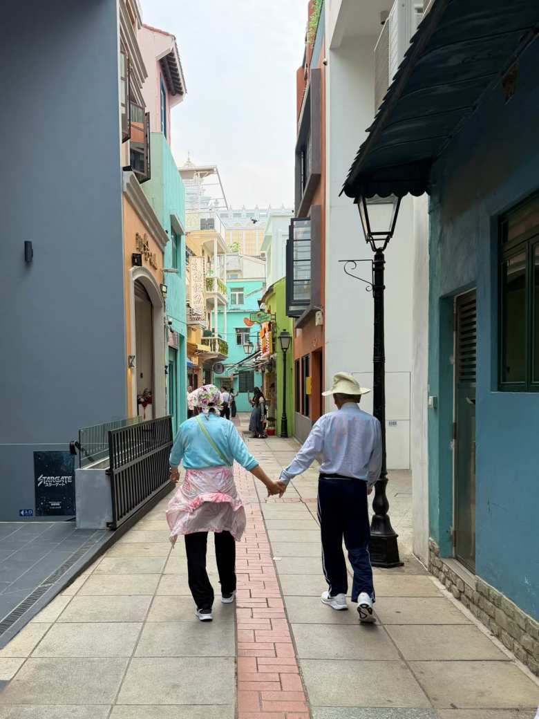 My dad nd his sister walk hand-in-hand through one of the city's most famous culinary and cultural streets of Taipa Village in Macau.