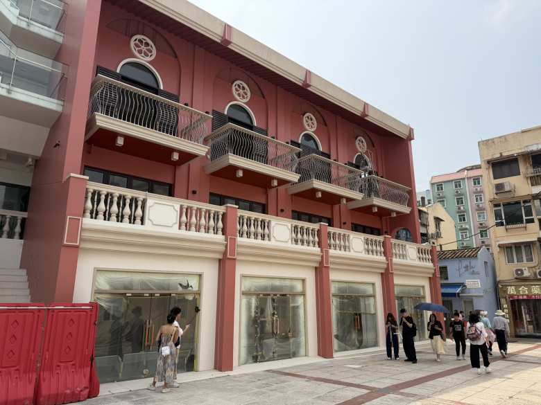 Elegant balconies and arched windows stand out against a warm terracotta building, showcasing the beautiful Mediterranean influence found throughout the streets.