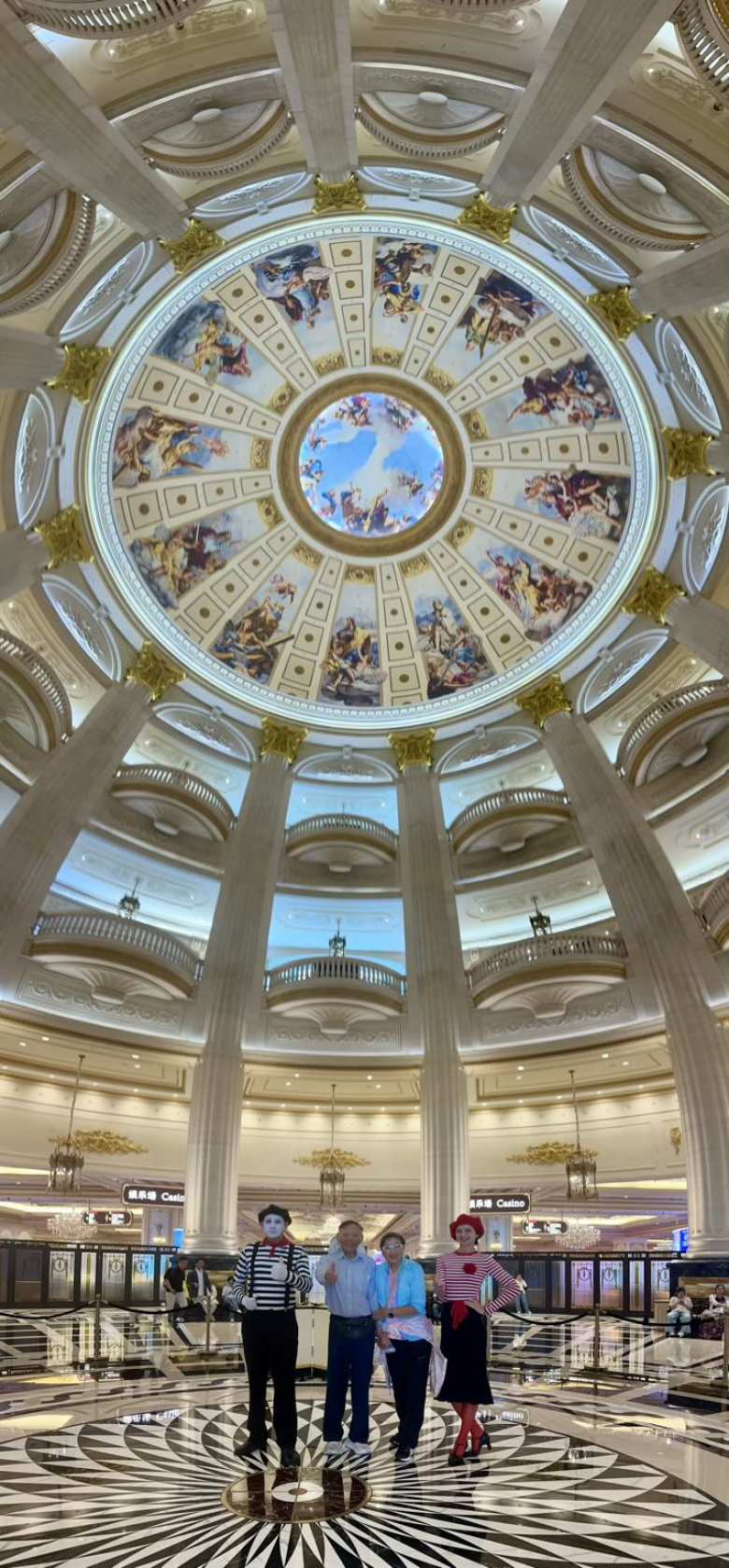 My dad and aunt pose with mimes beneath the hand-painted frescoes of the Grand Lisboa Palace dome.
