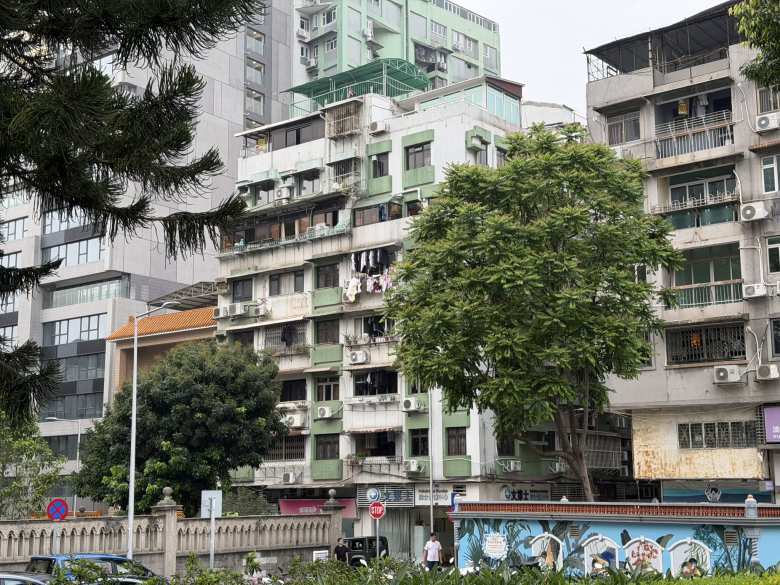 Laundry hangs from the balconies of a local apartment block, offering a glimpse into the everyday urban texture of Macau's residential neighborhoods.