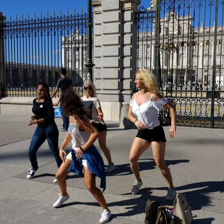 Folks practicing a choreographed dance in front of the Royal Palace of Madrid.