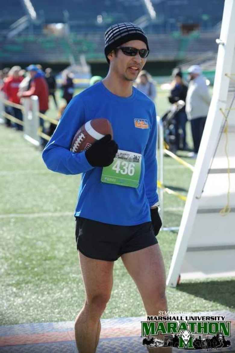 Felix Wong with a football after crossing the finish line of the 2019 Marshall University Marathon.