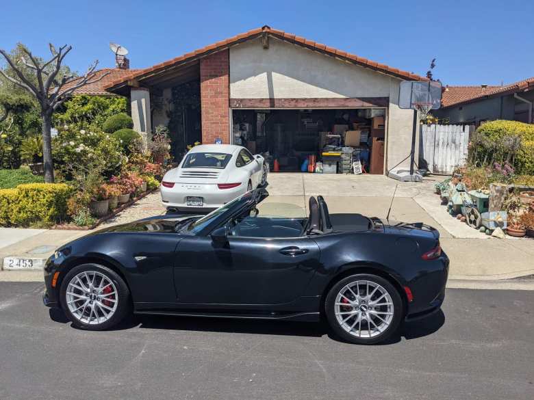 white Porsche 911, black 2016 Mazda MX-5 Miata with top down