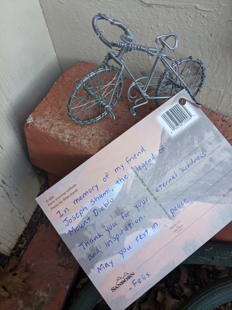 A postcard and bicycle left for Joseph Shami a few weeks after his passing.