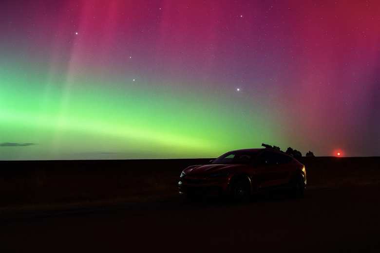The aurora borealis over my red Mustang Mach-E.