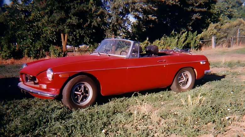 red 1974 MGB roadster in back yard