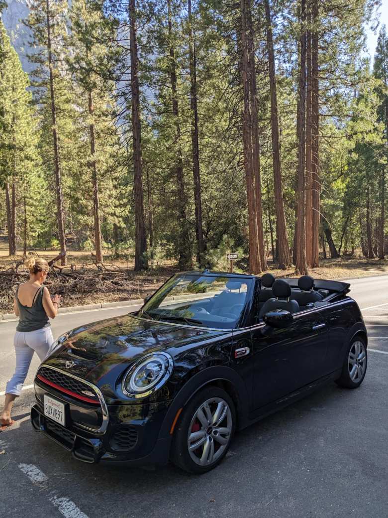 Andrea walking by the MINI Convertible in Yosemite with the top down.