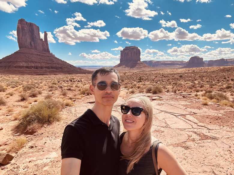 Felix and Andrea in front of West Mitten Butte, East Mitten Butte, and Merrick Butte.