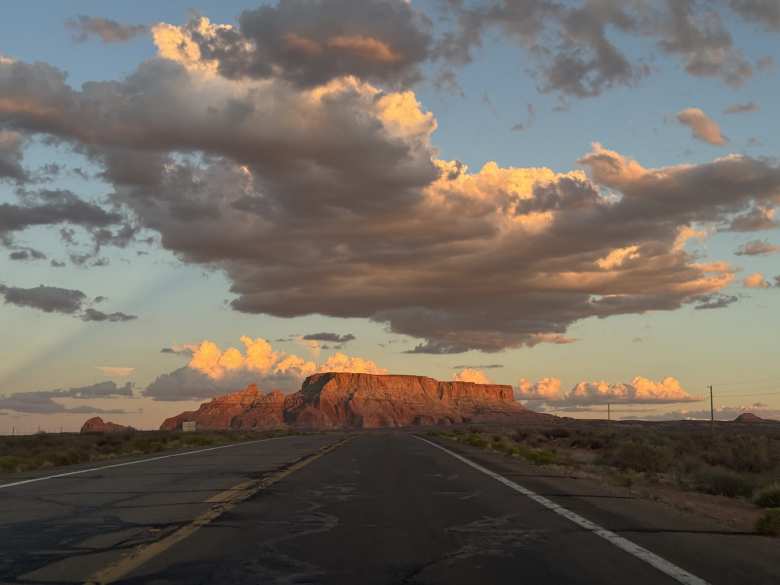 Driving towards a flat-topped mesa under a large cloud on Highway 98 east of Page, Arizona.