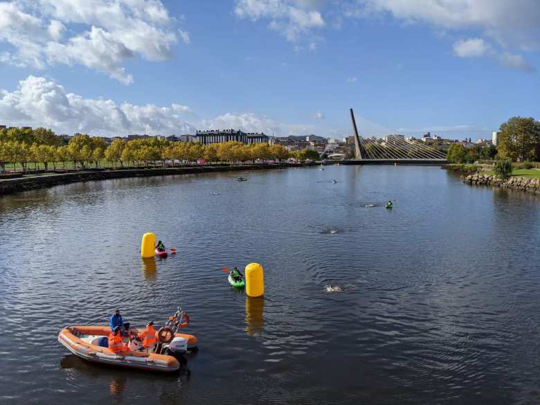 A one-armed triathlete swimming around a yellow buoy in the 750-meter swim course in the Rio Lérez during the National Sprint Triathlon Championship in Spain.