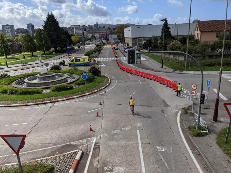 A triathlete navigating through a roundabout on Avenida Compostela.