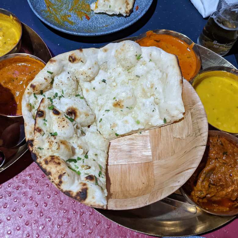 Garlic naan with curry dishes at Mum Indian Restaurant in Nerja.