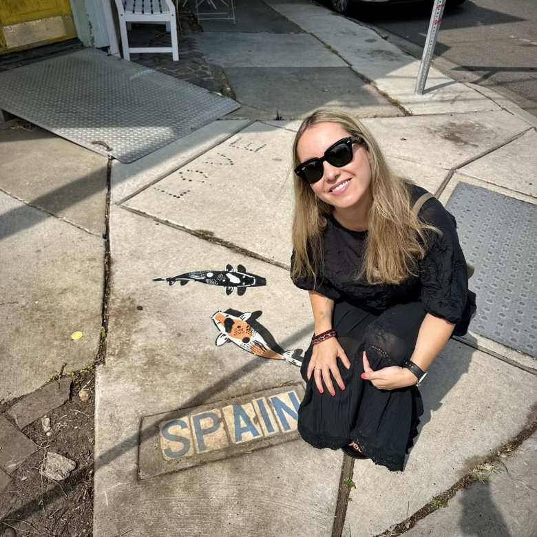 Andrea with a Spain sign on the sidewalk.