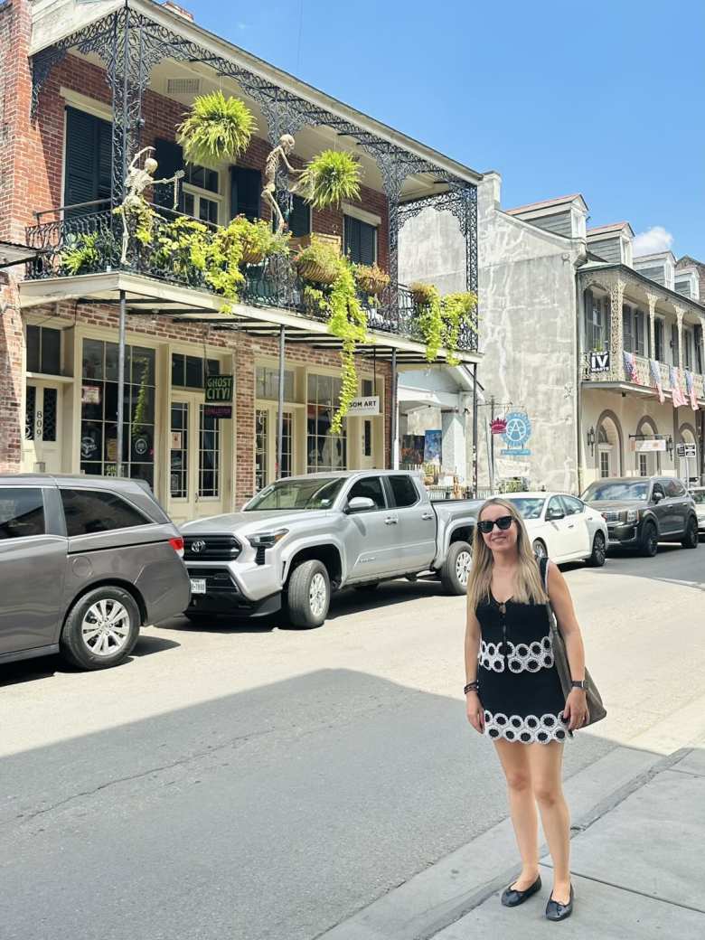 Andrea in front of a building in the  French Quarters that had skeletons on the balcony. 
