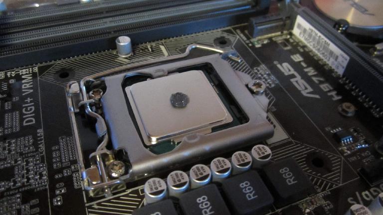 Applying a pea-sized bit of IC Diamond thermal paste to the CPU, just as IC Diamond's website instructed.