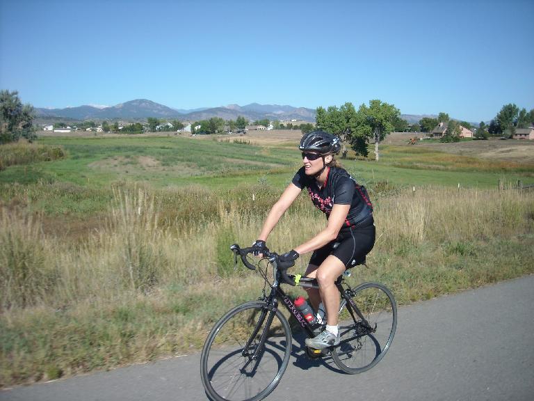 Celeste riding by green countryside.