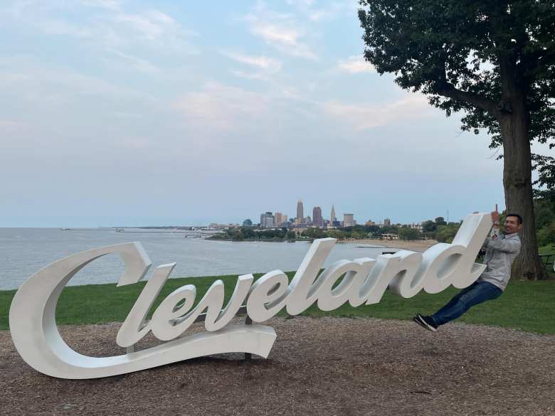 Felix hanging off the Cleveland sign at Edgewater Park, with downtown Cleveland in the background.