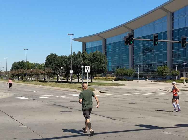 Manuel tried to get a photo of Mel (right) as she came into the final 300 meters of the 2019 Omaha Marathon.