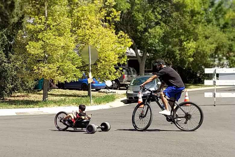 A boy riding a bicycle followed by a man riding a hardtail mountain bike.