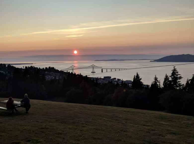 Then sun setting over the Pacific Ocean west of the US-101 bridge connecting Astoria, Oregon to Chinook, Washington.