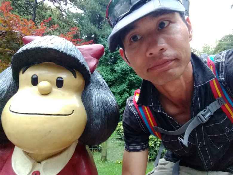 Felix Wong with the statue of Mafalda (an Argentine comic character) in the park Campo de San Francisco.