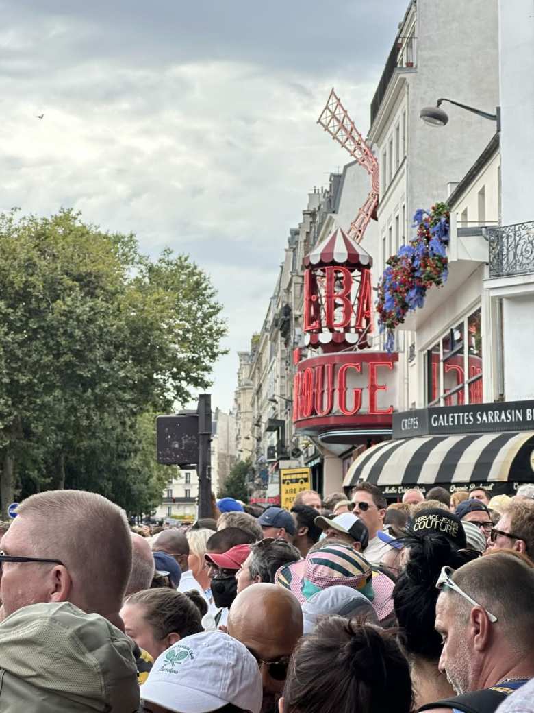 Spectators watching the men's Olympic cycling road race near the Moulin Rouge.