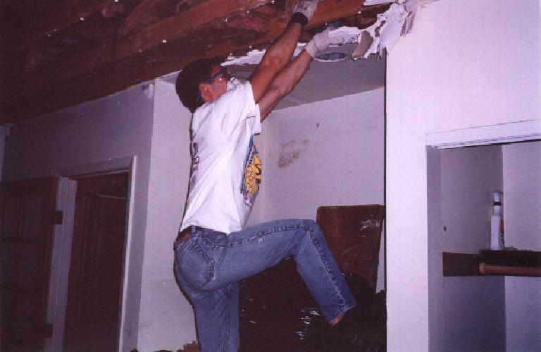Felix Wong hanging off of a beam to rip out the ceiling!