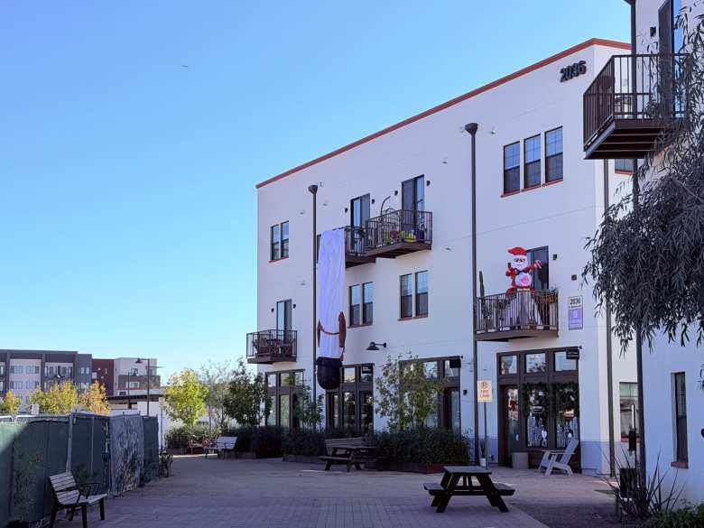 A droopy inflatable snowman hanging over a balcony railing at Culdesac Tempe.