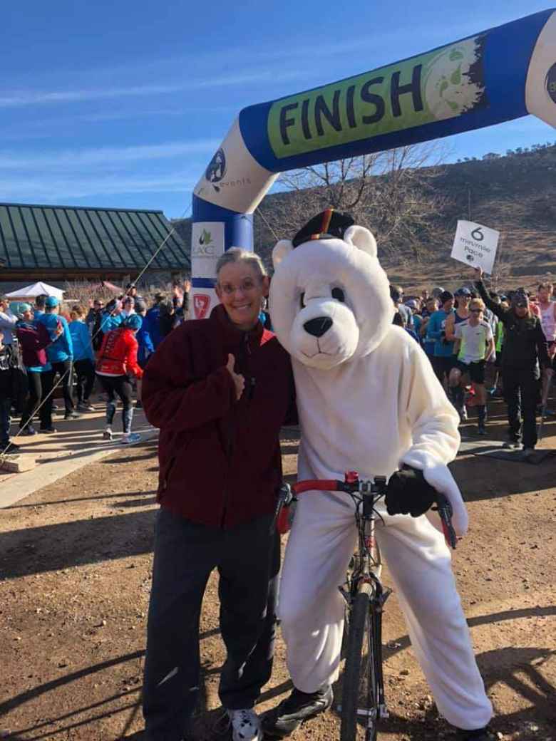 The polar bear mascot in position to pace the lead runners of the 2019 Polar Bear 5k Run on a bicycle.