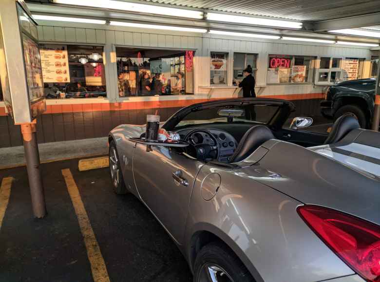 Having dinner inside a Pontiac Solstice GXP at the A&W drive-in restaurant in Florence, Oregon.