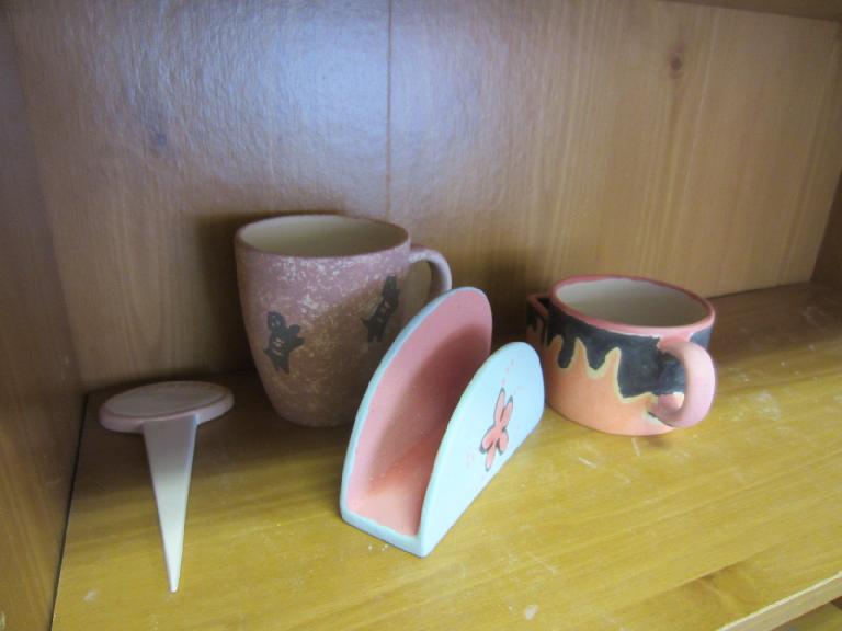 Tori's garden stake and flying cats mug; Raquel's napkin holder; and my tea cup before glazing.