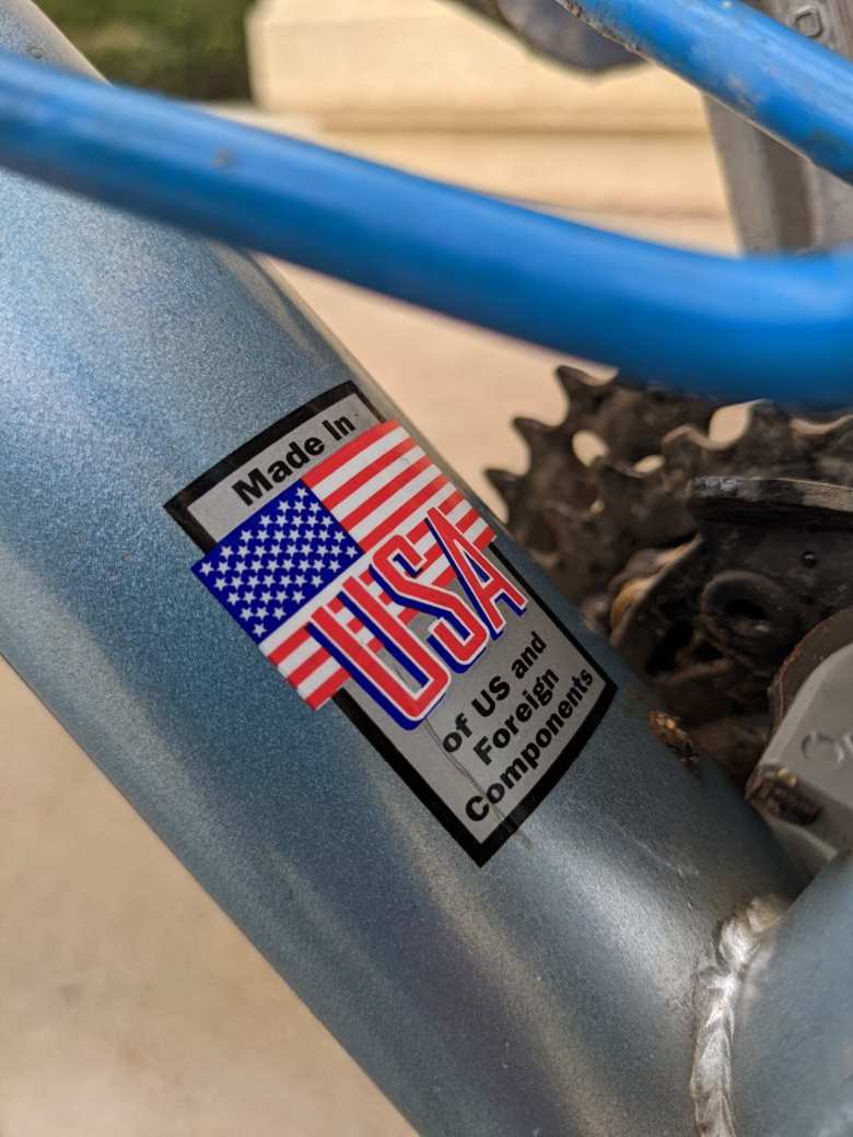 The downtube sticker on this blue Raleigh M300 mountain bike reads "Made in USA of US and foreign components."