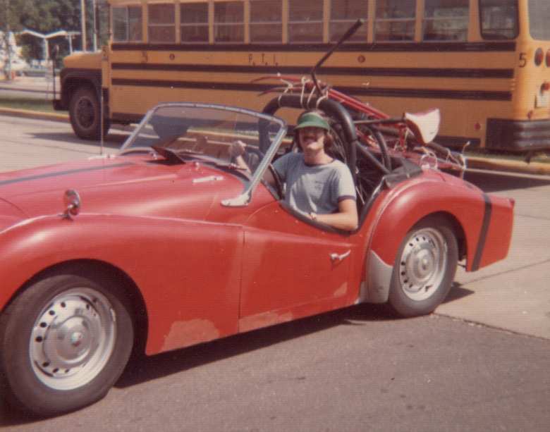 Dan Shockey in his red Triumph TR3 with a bicycle tied to its luggage rack when he was in college.

