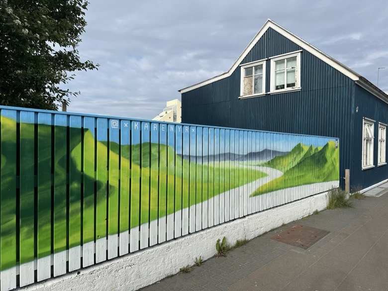 A beautiful mural of green hillsides on a fence in Reykjavik.
