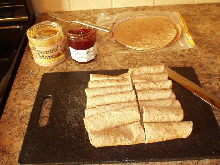 [Day before the brevet] Making a bunch of tortilla rollups with peanut butter and strawberry preserves.  Also made oatmeal raisin cookies and packed some fig bars.