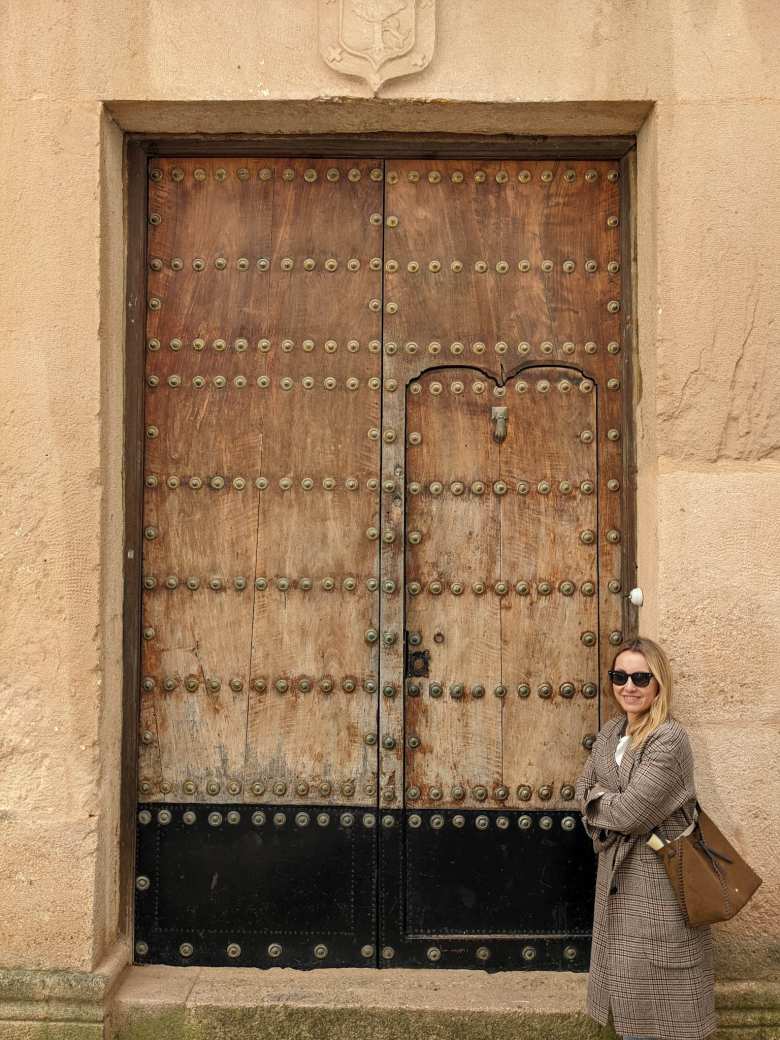 Andrea in front of the door that is part of the Palacio de Mondragón.
