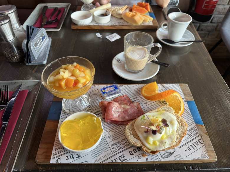 My breakfast at the Ocean Café consisted of fruit salad, gelatin, bacon, egg on bread, and butter.