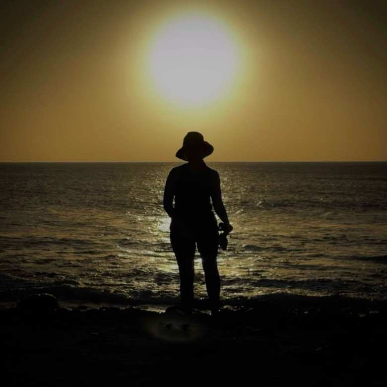 Andrea in front of a setting sun on at Ponta Preta Beach in Sal, Cabo Verde.