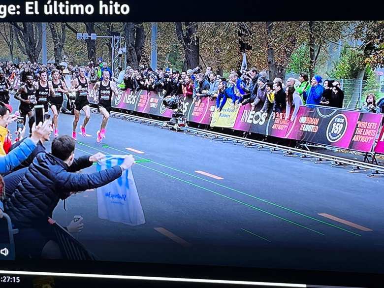 Antxon's photo of a scene from the movie, "Kipchoge: El Último Hito." You can see me standing to the left of the guy holding the white shirt with blue stripes.