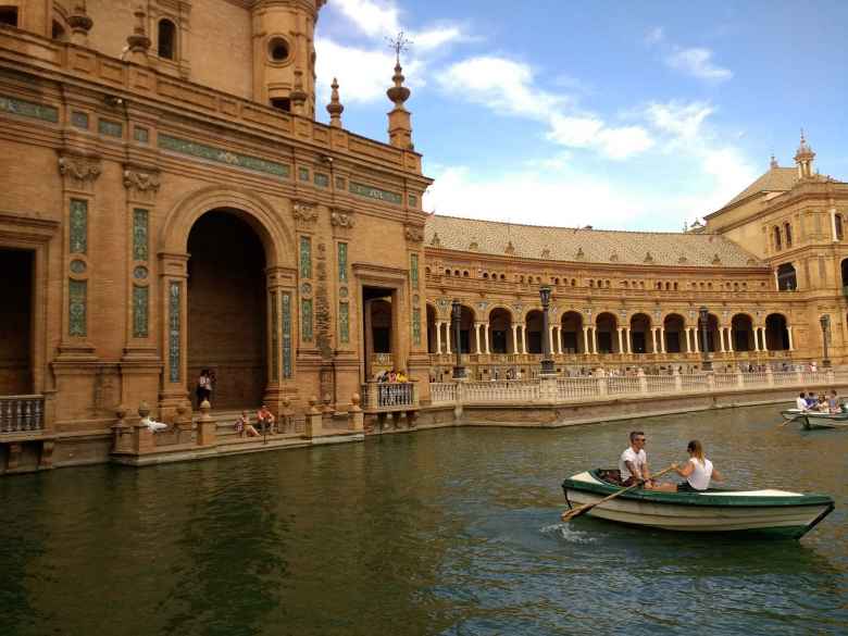 A woman rowing a canoe in the canal at the Plaza de España in Seville, Spain.